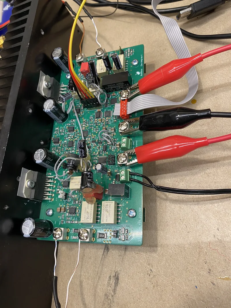 Dev AMP prototype board on the test bench, with probes clipped to the output terminals