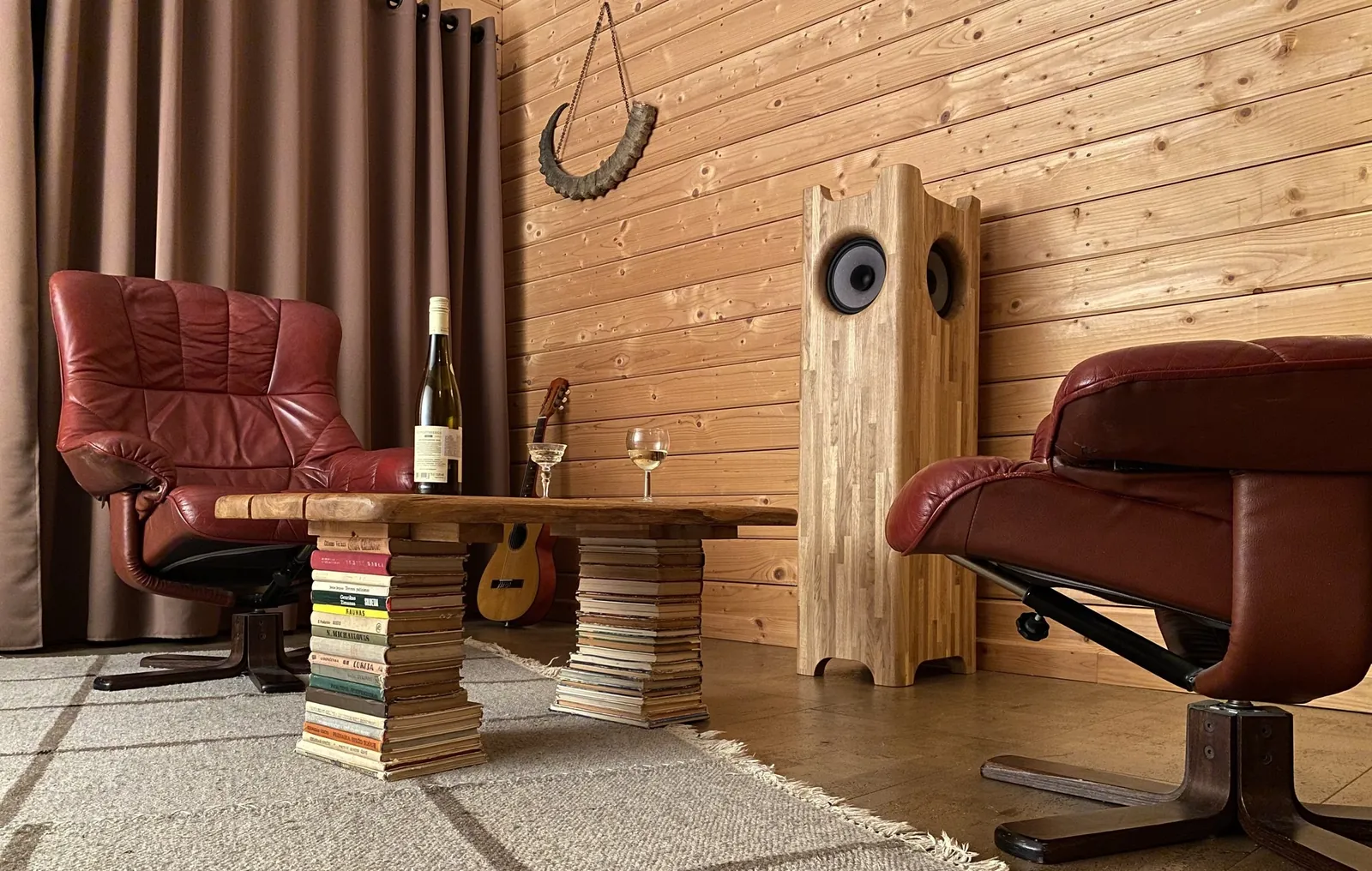 Earlier Baffless Single Speaker Stereo oak enclosure in a listening room between two chairs